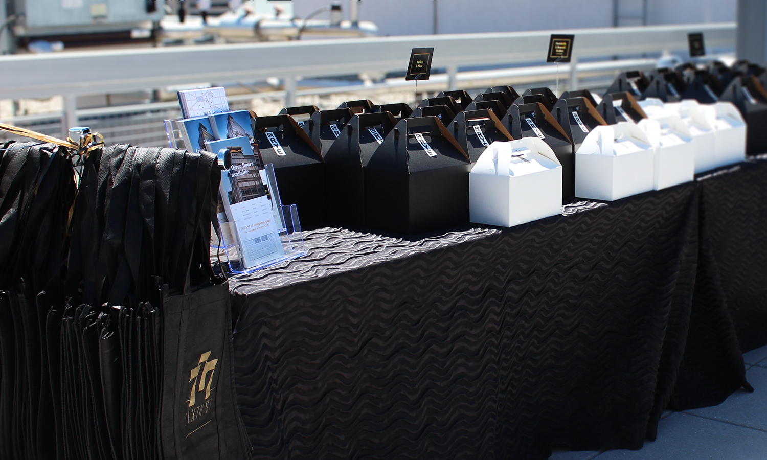 777 Sixth event photo: table with logo tote, flyers, and table cards